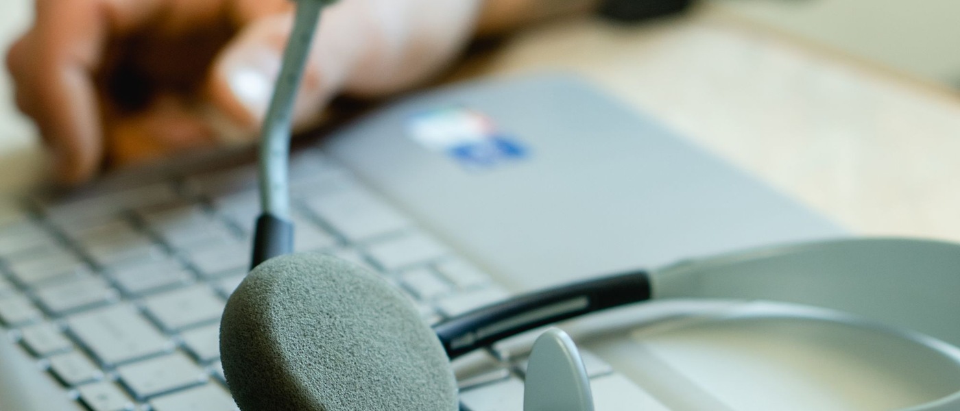 Casque-micro posé sur le clavier d’un ordinateur portable.