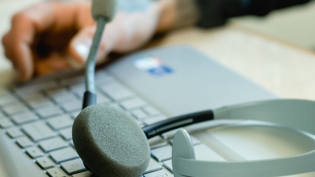 Casque-micro posé sur le clavier d’un ordinateur portable.