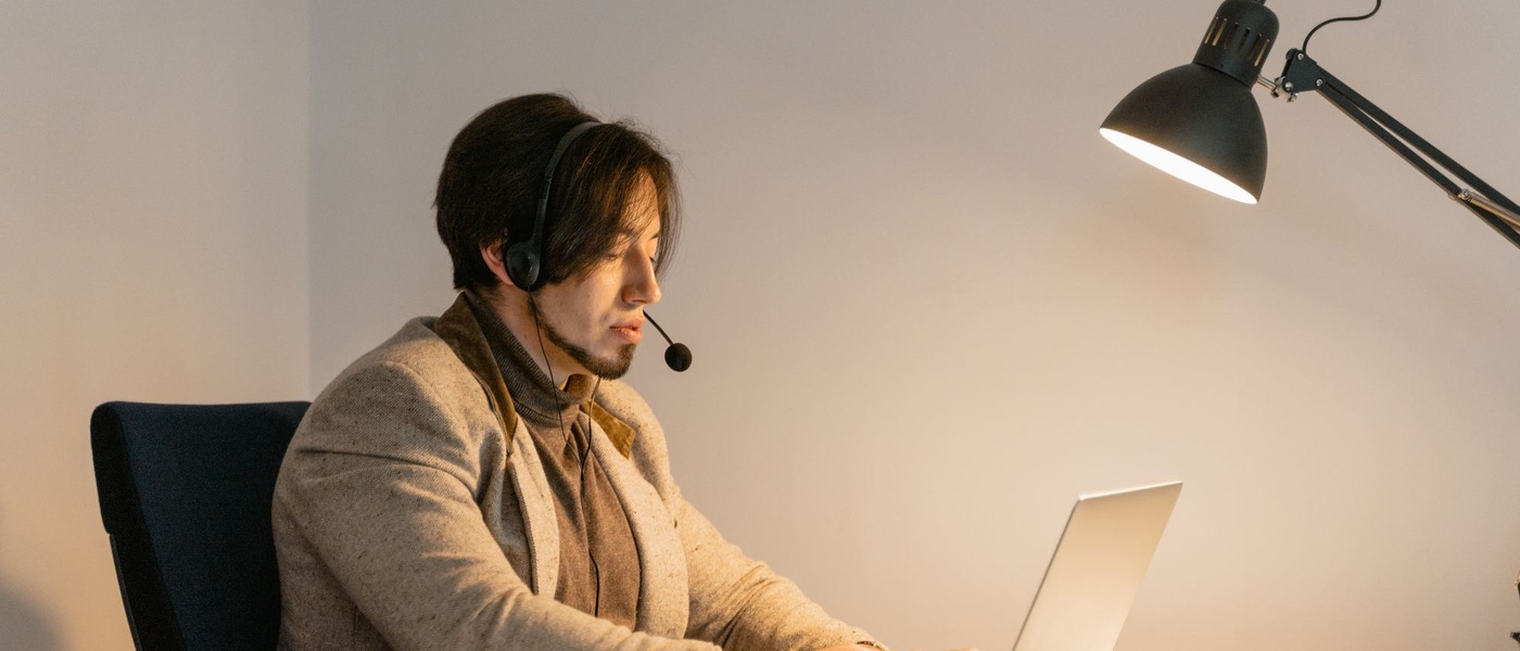 Homme de profil portant un casque-micro dans un bureau.